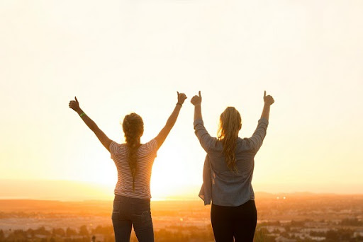 2 people cheering with sunset